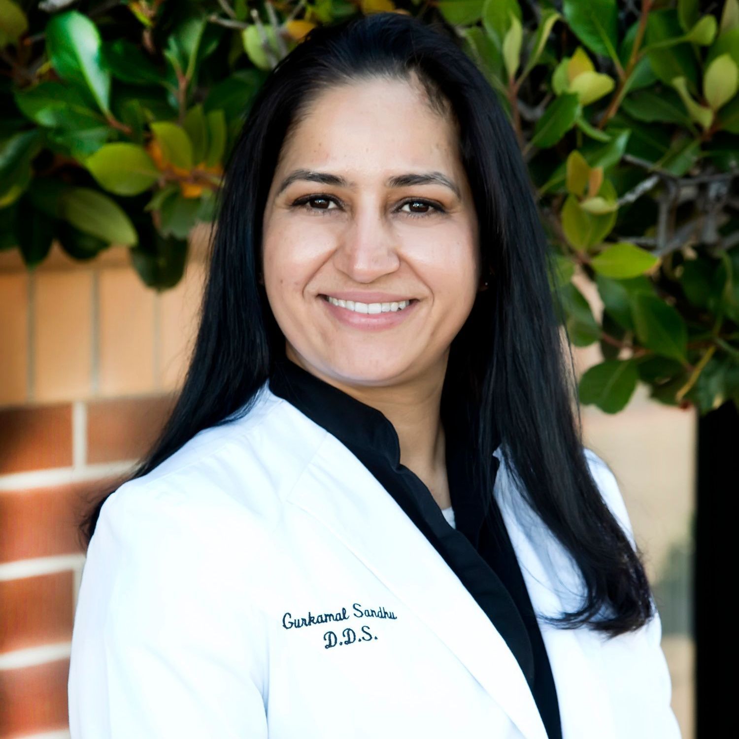 Dr. Gurkamal Sandhu, DDS A woman wearing a white coat with the name ganshal smith on it