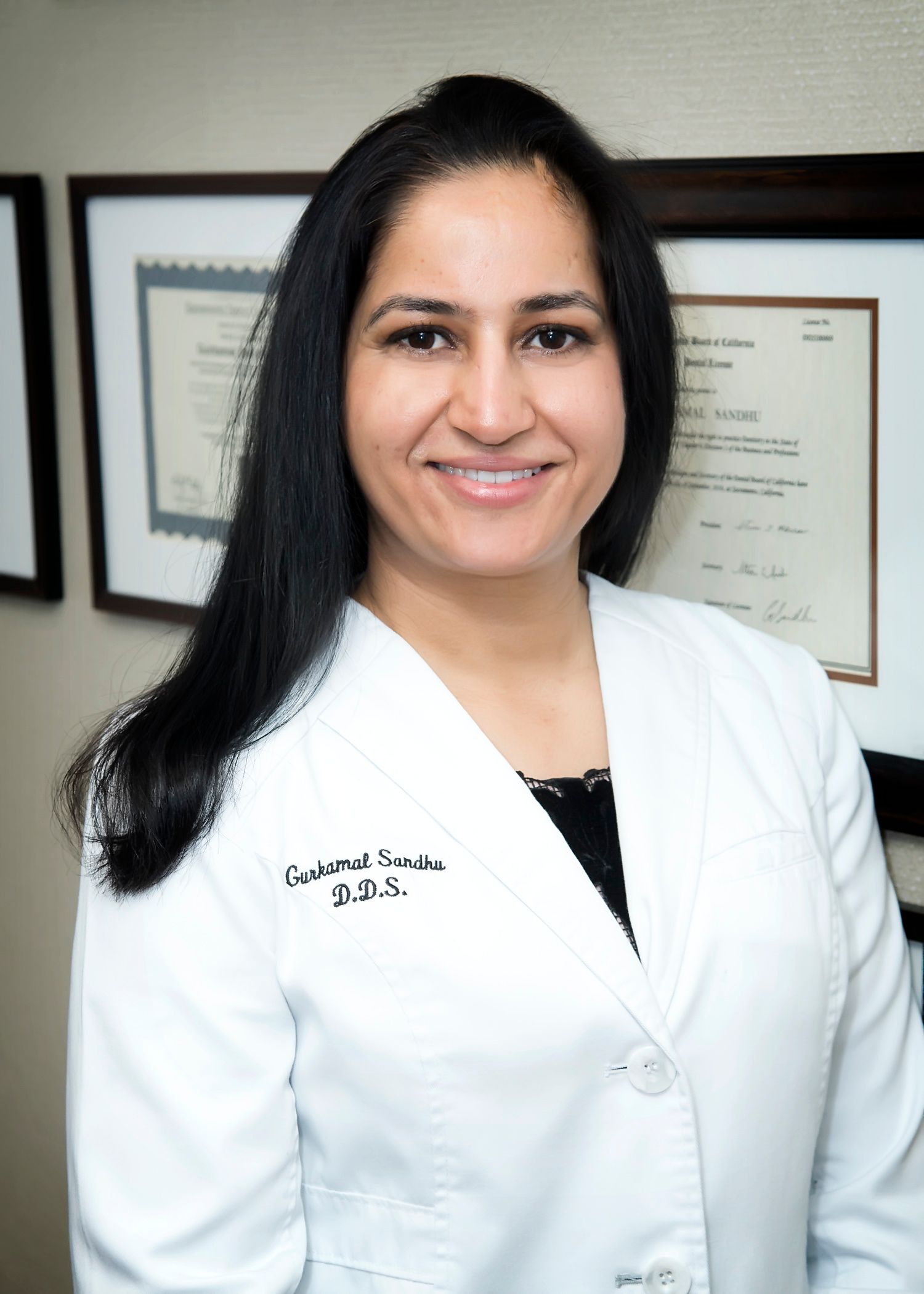 A woman wearing a white lab coat with the name laura on it