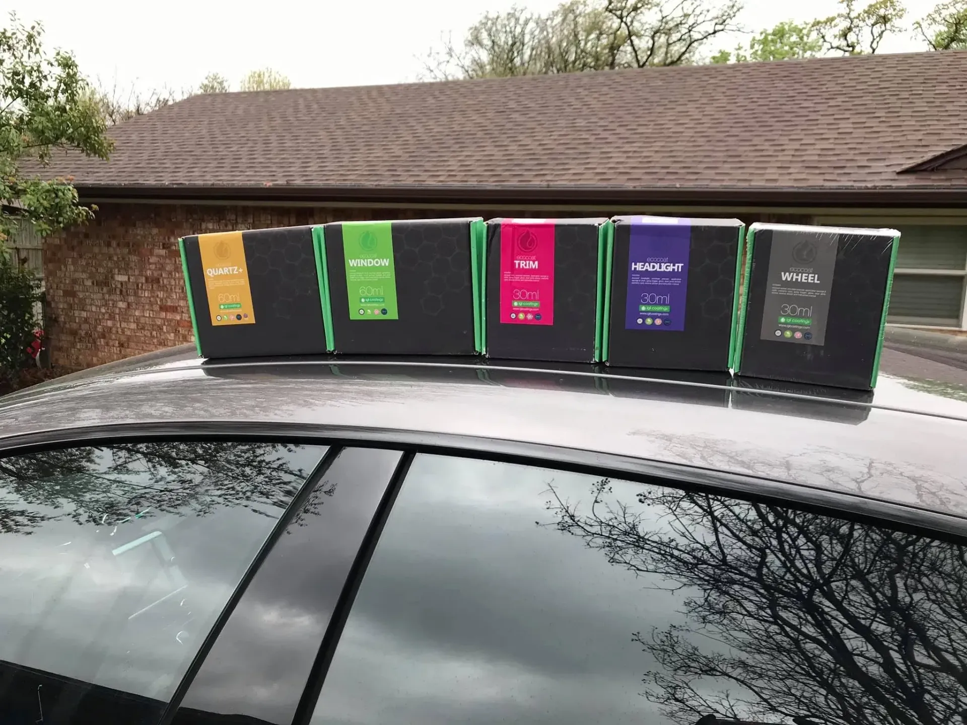 IGL coatings lined up on a car roof in a driveway.
