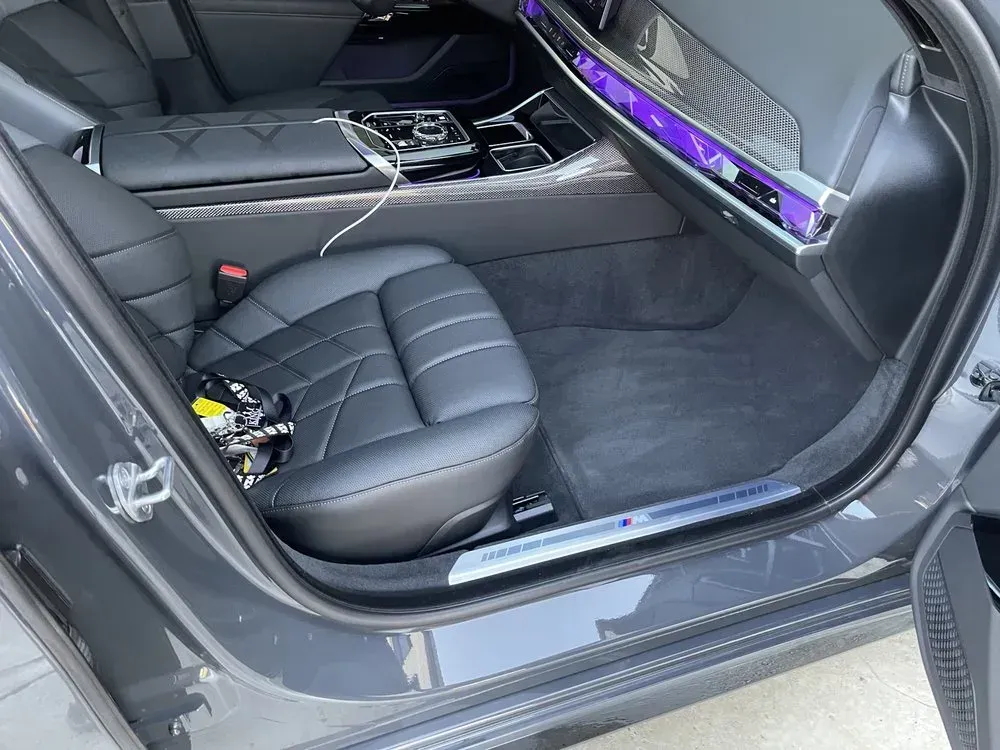 Car interior with black leather seats and purple ambient lighting along the dashboard and door trim Car interior with black leather seats and purple ambient lighting along the dashboard and door trim