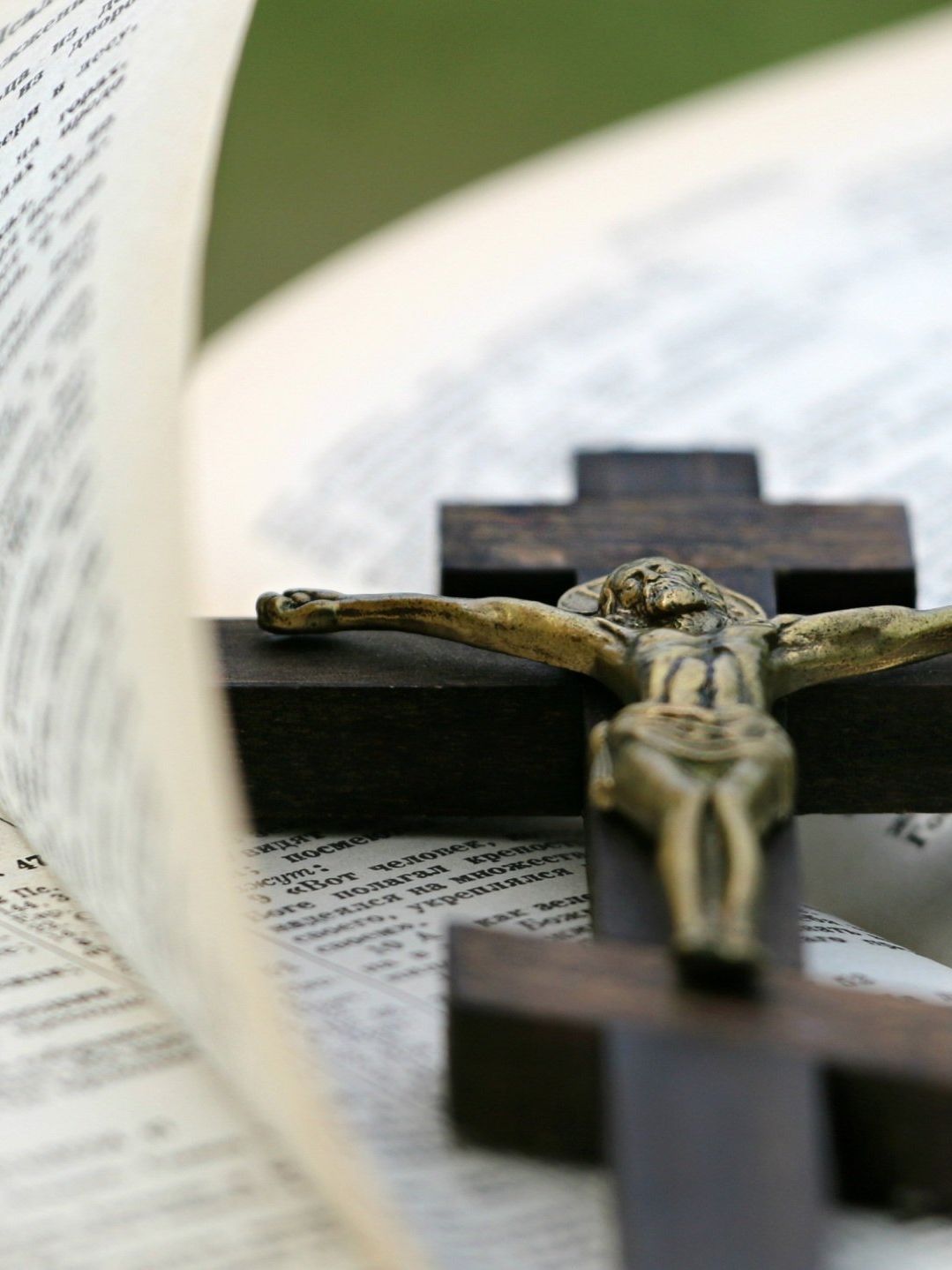 Crucifix on an open book with blurred pages in the background