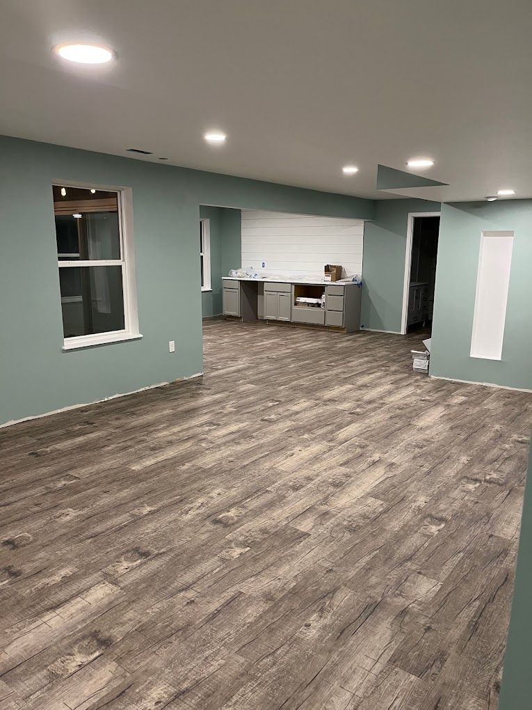 A large room with a wooden floor and green walls.