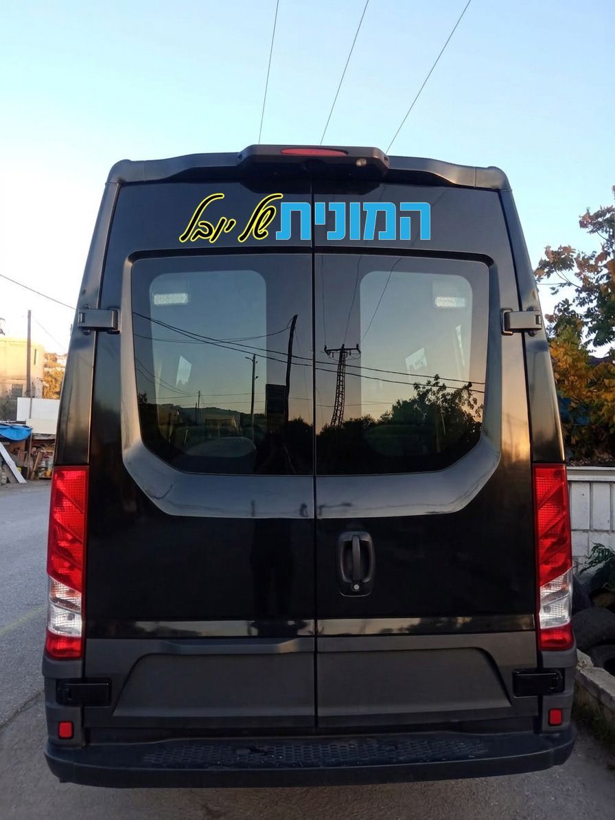 מבט אחורי על מיניבוס הסעות ממותג עם הלוגו 'המונית של יובל' וסמל מטוס, לשירותי הסעות לנתבג.