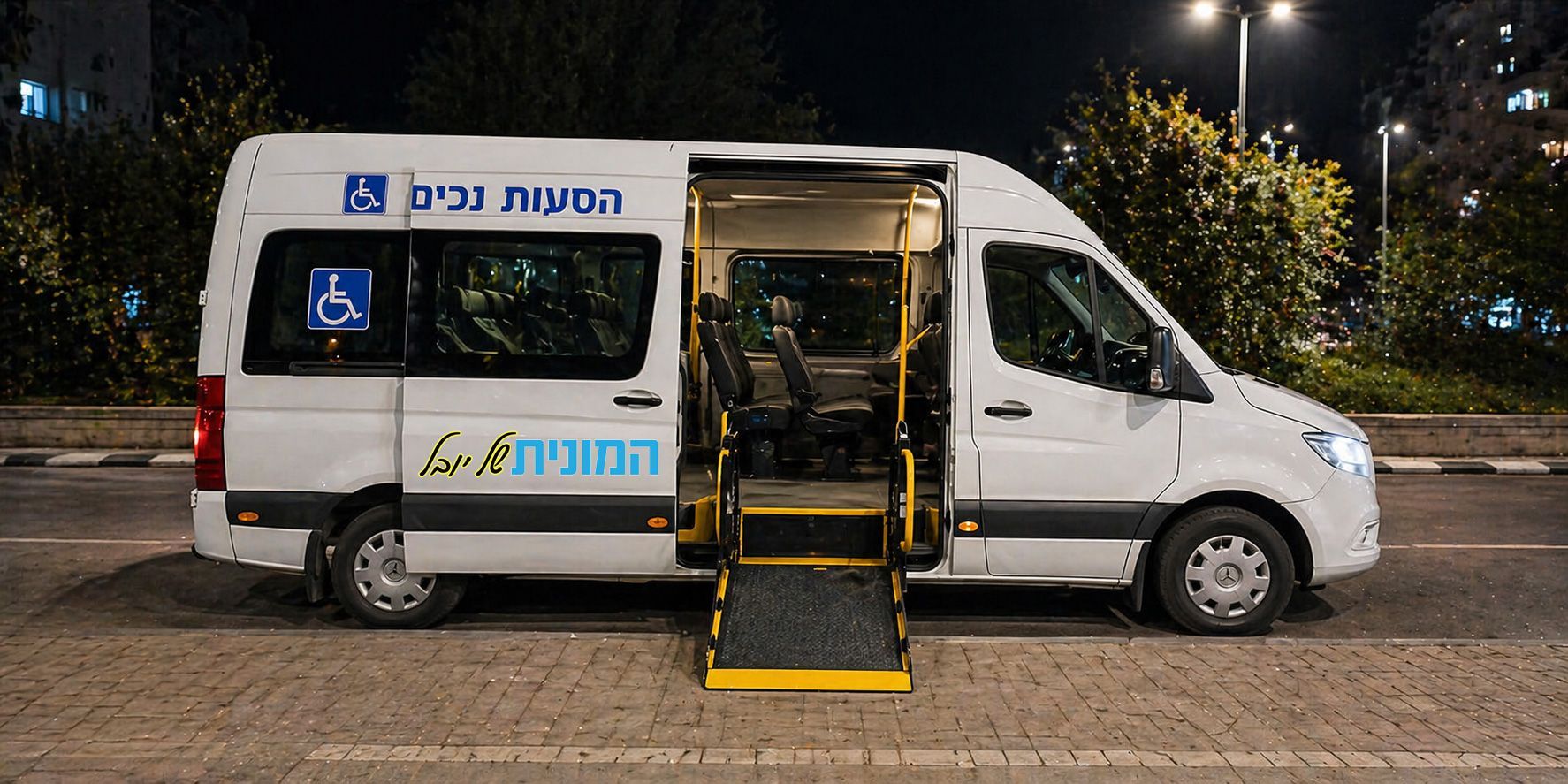 רכב הסעות מסחרי לבן חונה בלילה עם דלת צד פתוחה ומעלון נגישות מורד למדרכה, מותאם ובטיחותי עבור הסעת נכים בראש העין.