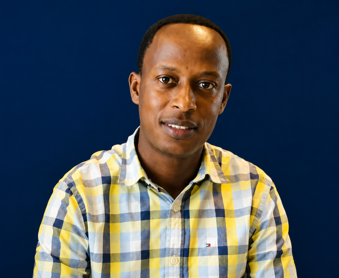 Portrait of a person in a yellow plaid shirt against a blue background