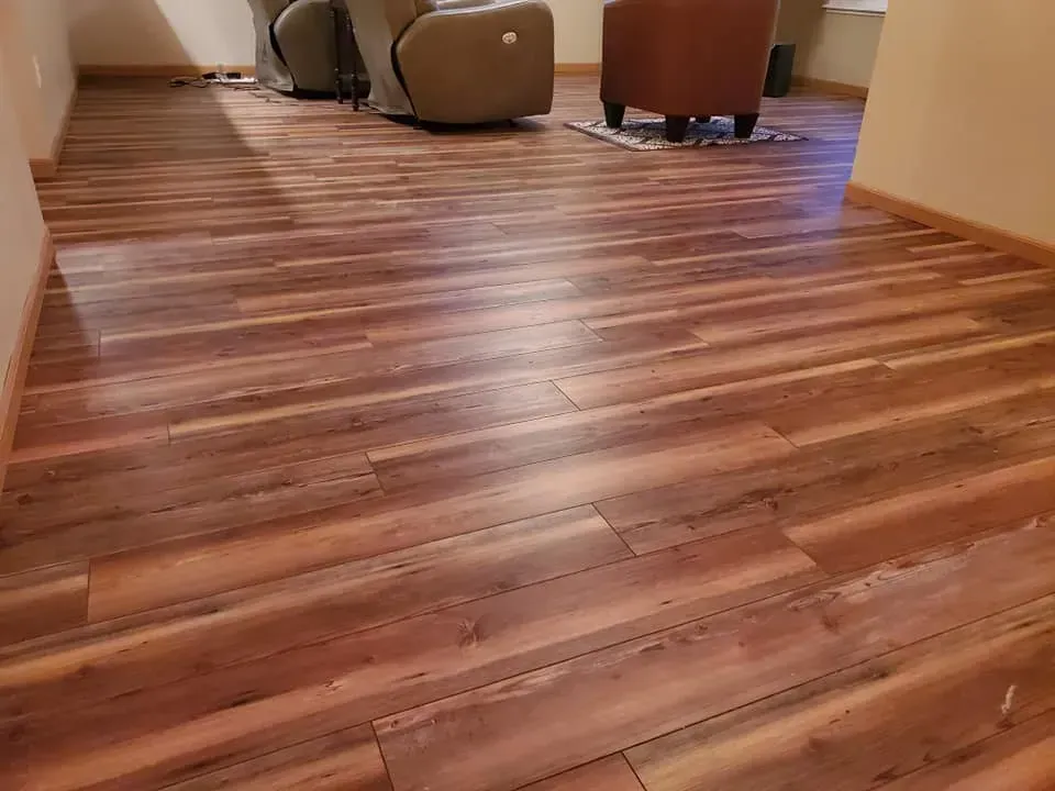 A living room with a wooden floor and chairs.