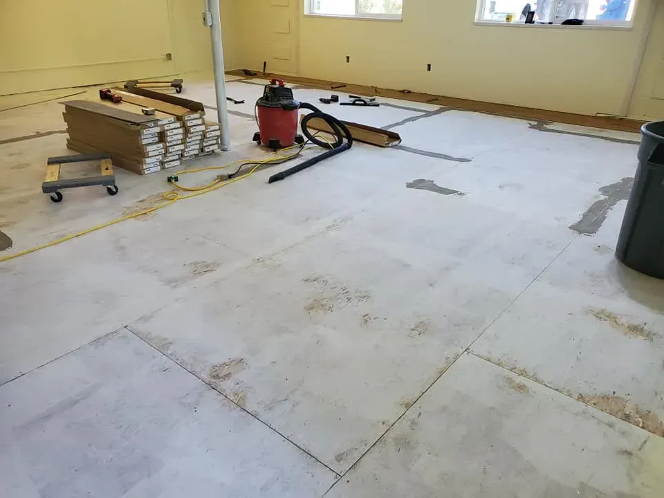 A vacuum cleaner is sitting on the floor of a room under construction.
