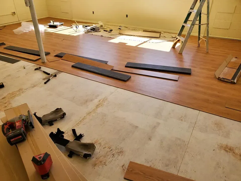 A room with a wooden floor and a ladder in it