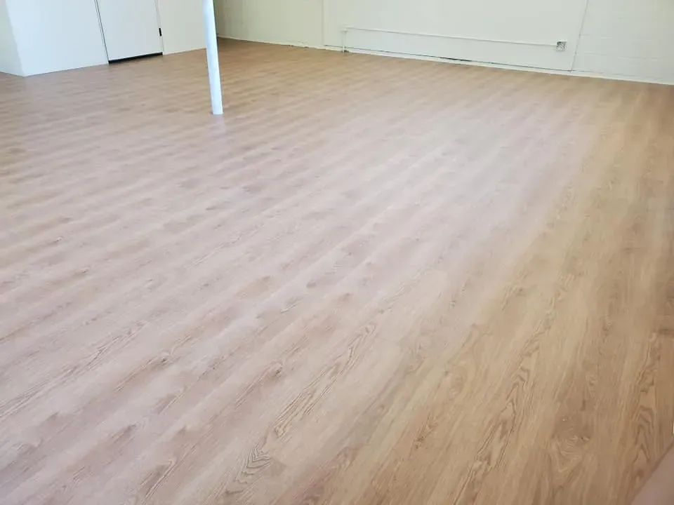 A large room with a wooden floor and white walls.