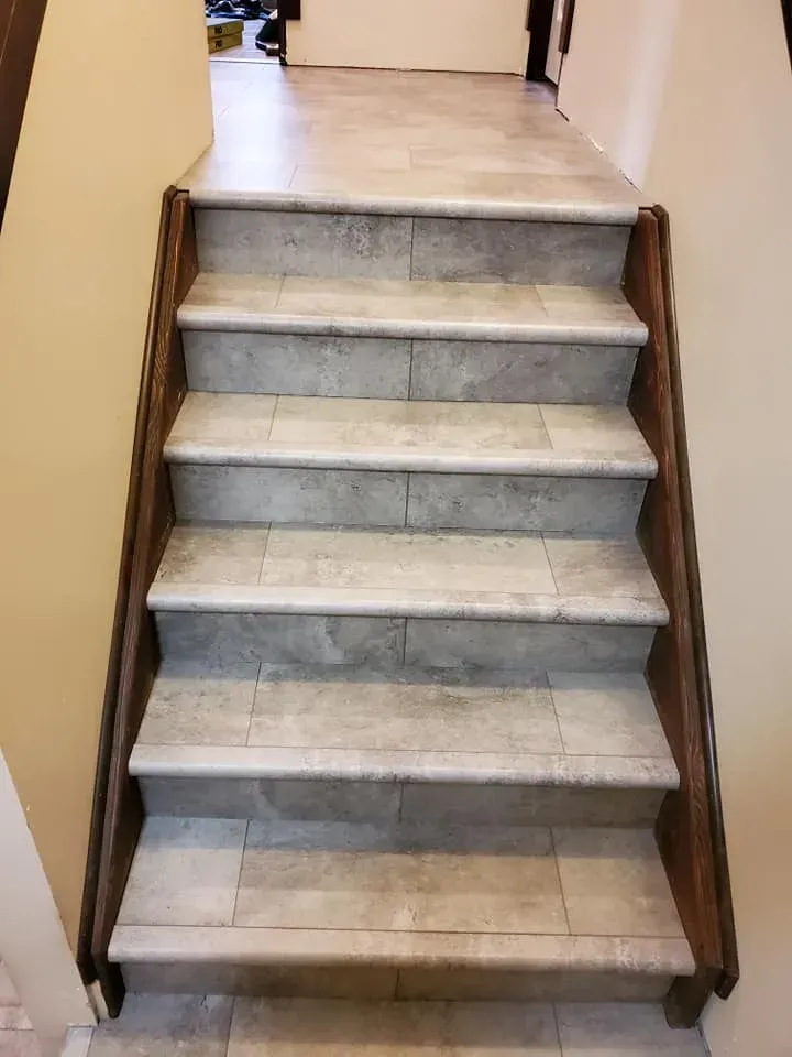 A set of stairs with a wooden railing in a hallway.