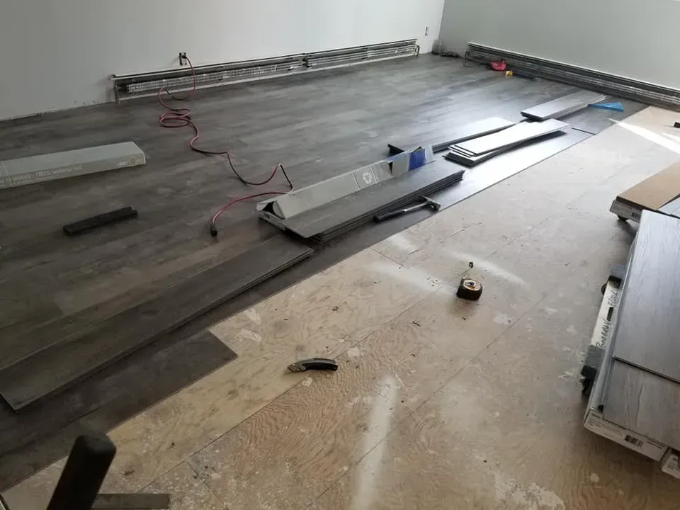 A room with a wooden floor being installed in it.