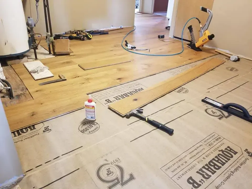 A wooden floor is being installed in a room.