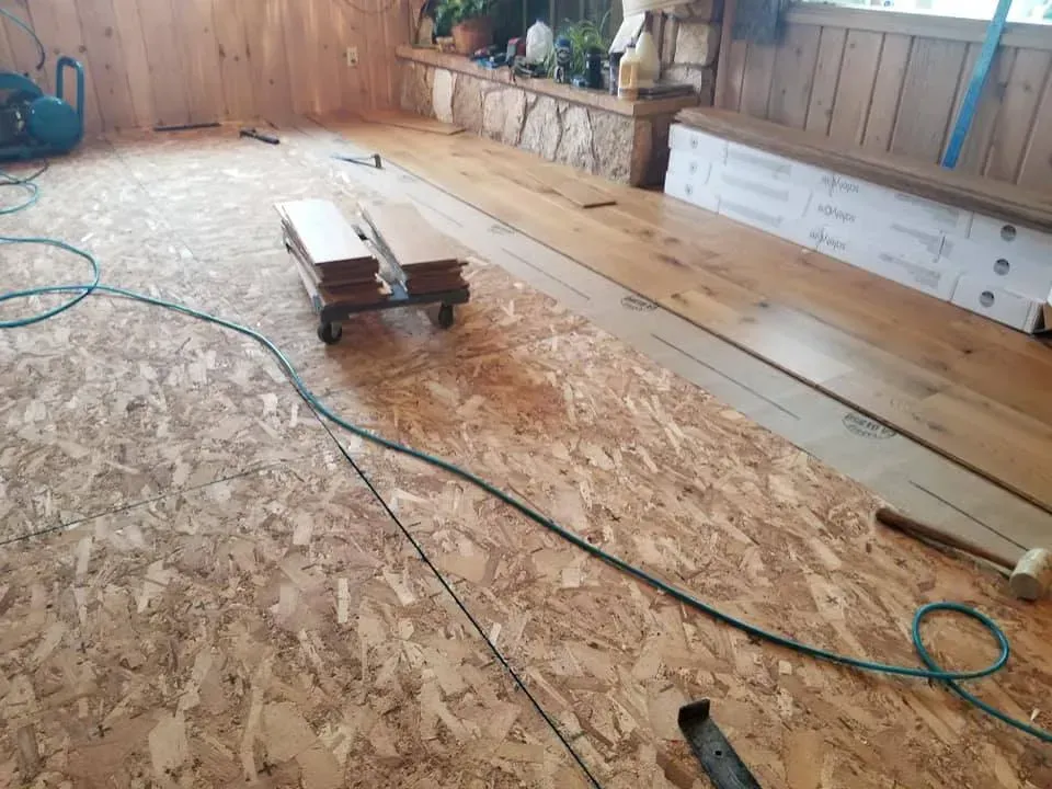 A wooden floor is being installed in a room.