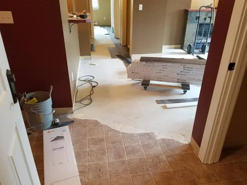 A hallway with hardwood floors being installed in a house.