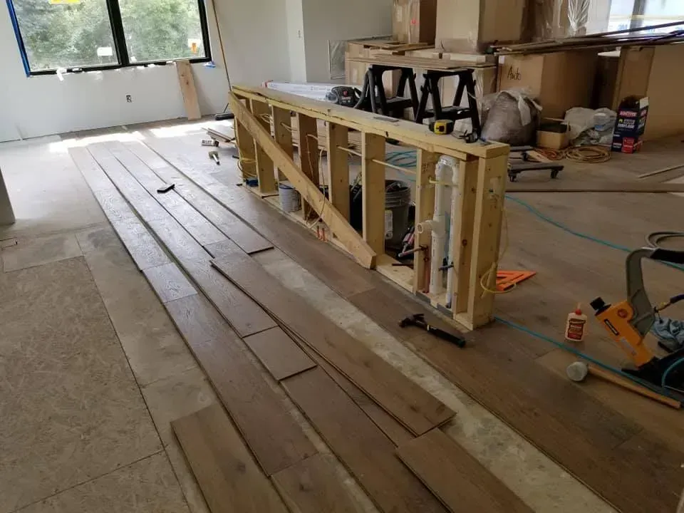 A room under construction with wooden floors and a wooden railing.