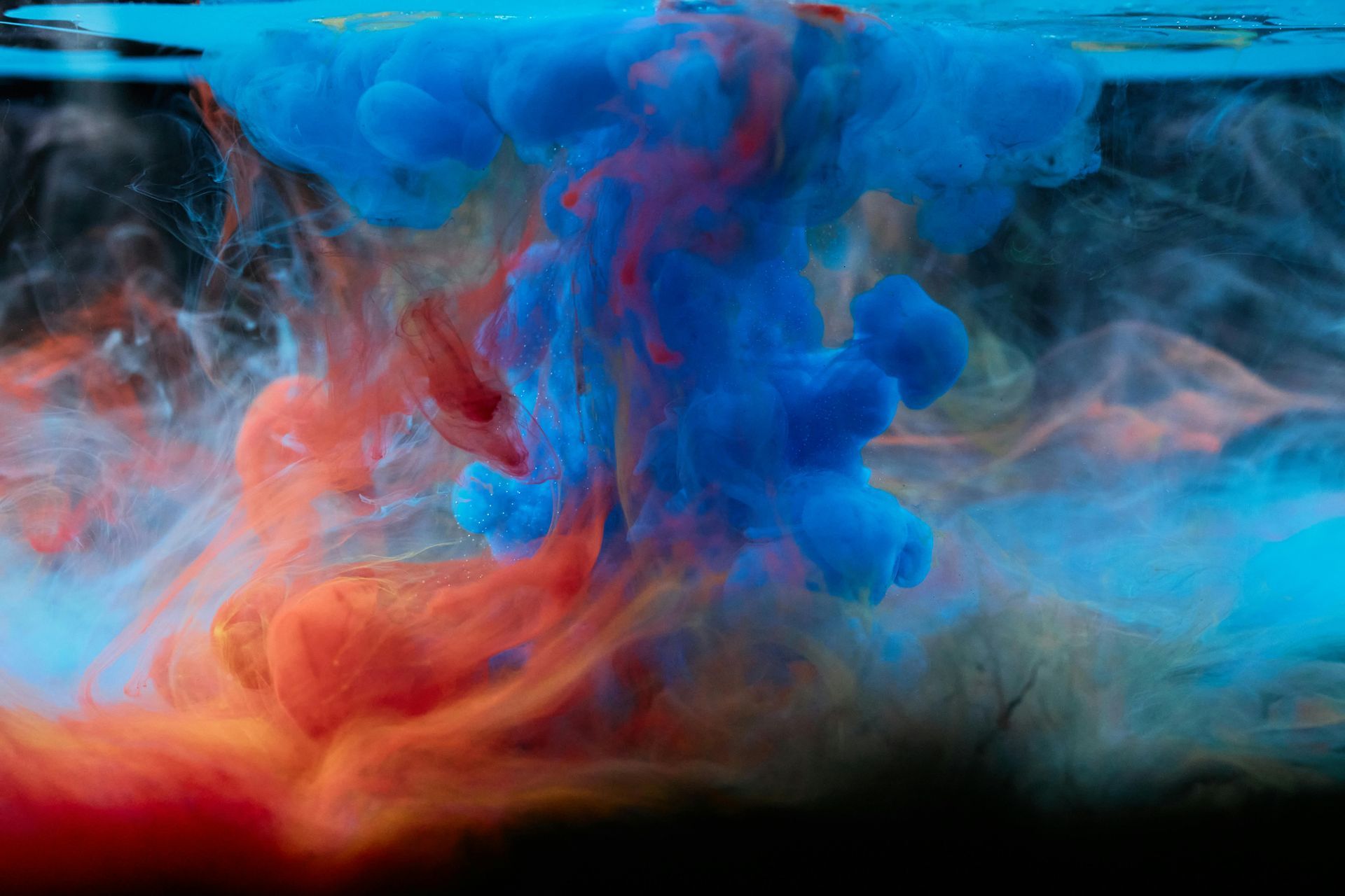 A close up of blue and orange ink in water.