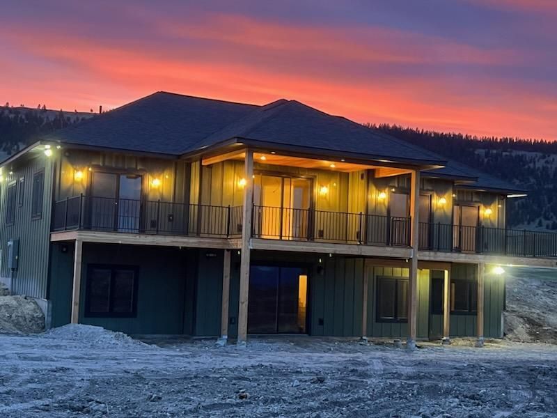 A large house with a balcony and a sunset in the background.