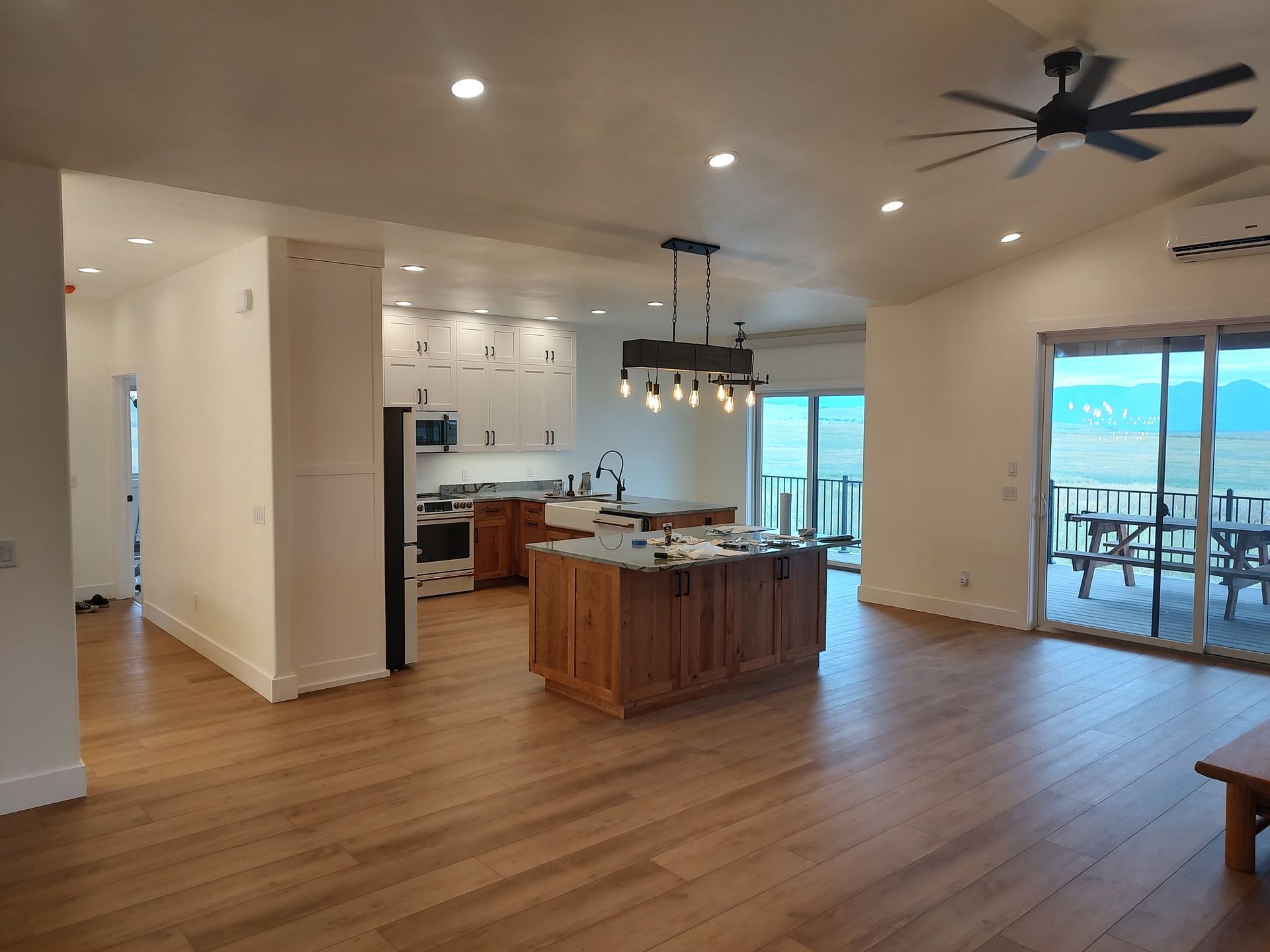 A kitchen with a large island in the middle of it and a ceiling fan.