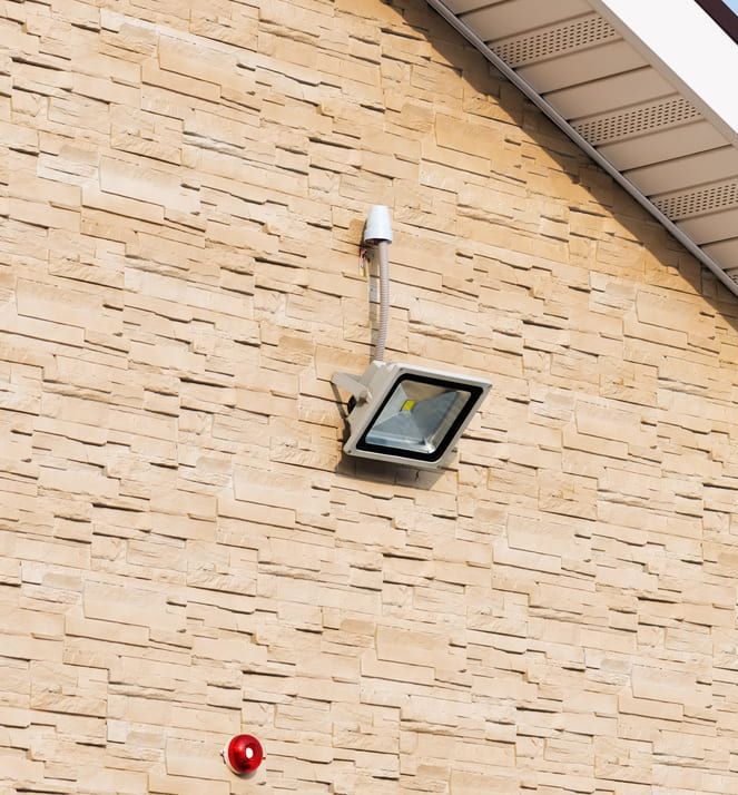 A Brick Wall with A Light Hanging from It — Jason Wenta Electrical Services in Condon, QLD