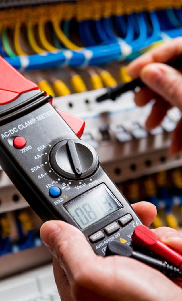 A Person Is Holding a Digital Multimeter in Their Hand — Jason Wenta Electrical Services in Condon, QLD