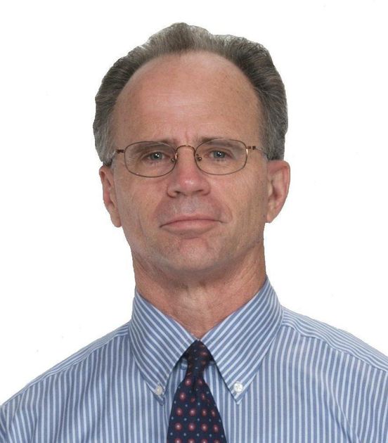 a man wearing glasses and a striped shirt looks at the camera
