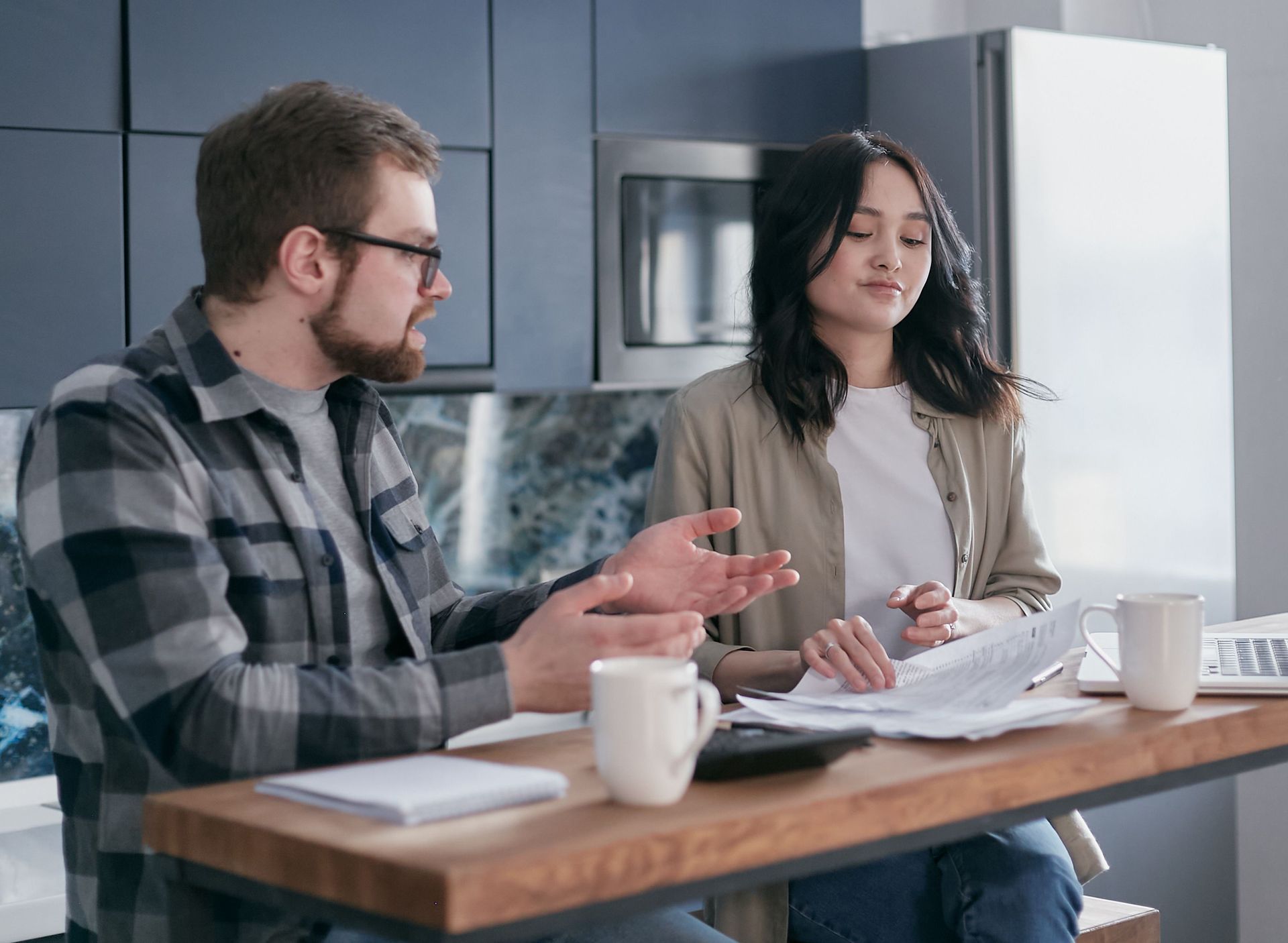 Colorado couple comparing two insurance plan options side by side at their kitchen table.