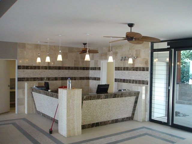 Modern kitchen with island, pendant lights, tiled backsplash, and large glass doors opening outside