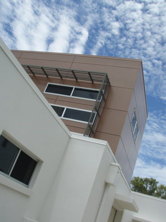 Modern building facade with windows against a partly cloudy sky