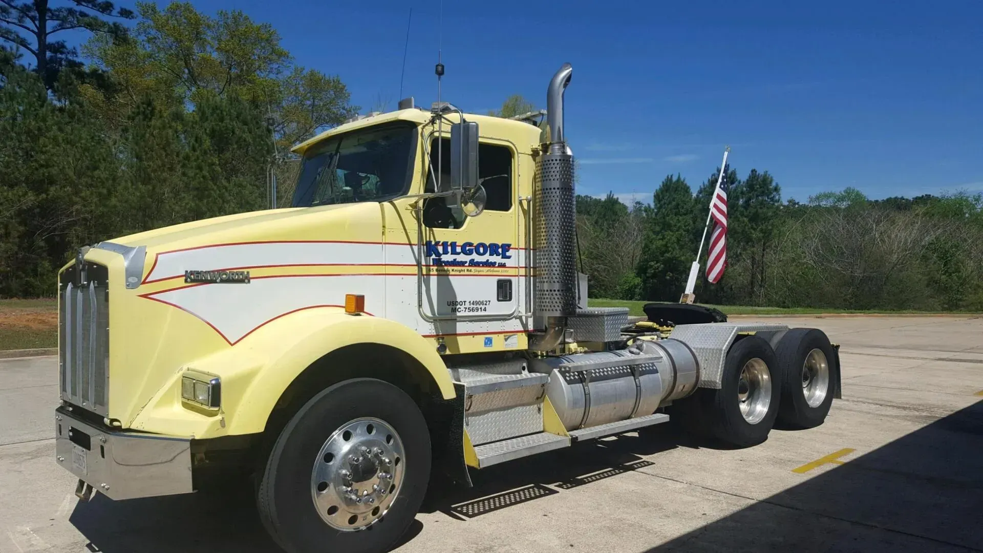 A yellow semi truck is parked on the side of the road.
