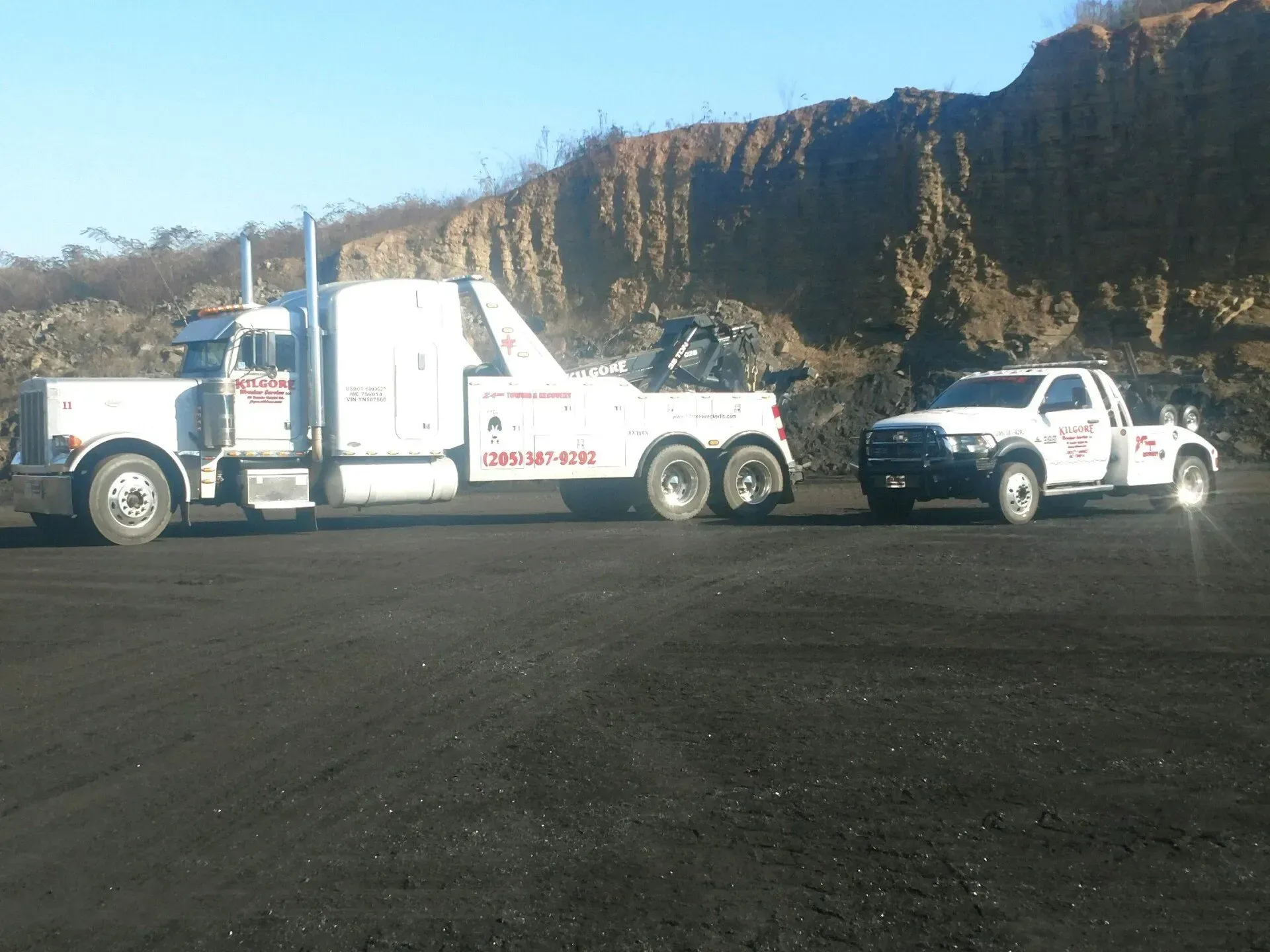 Two tow trucks are parked next to each other in a parking lot.