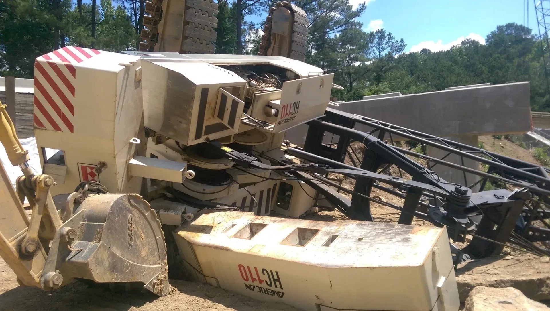A bulldozer is sitting on a dirt road with trees in the background.