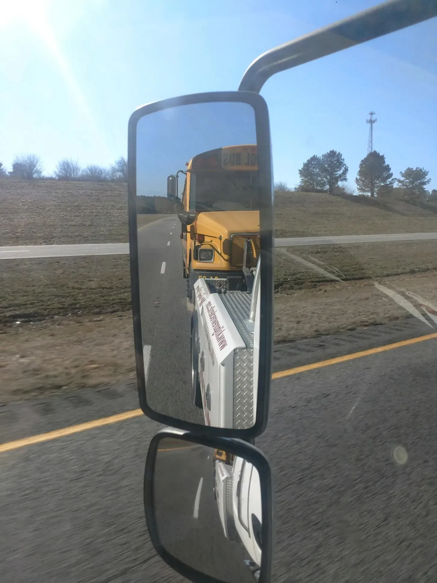 A school bus is reflected in a side view mirror.