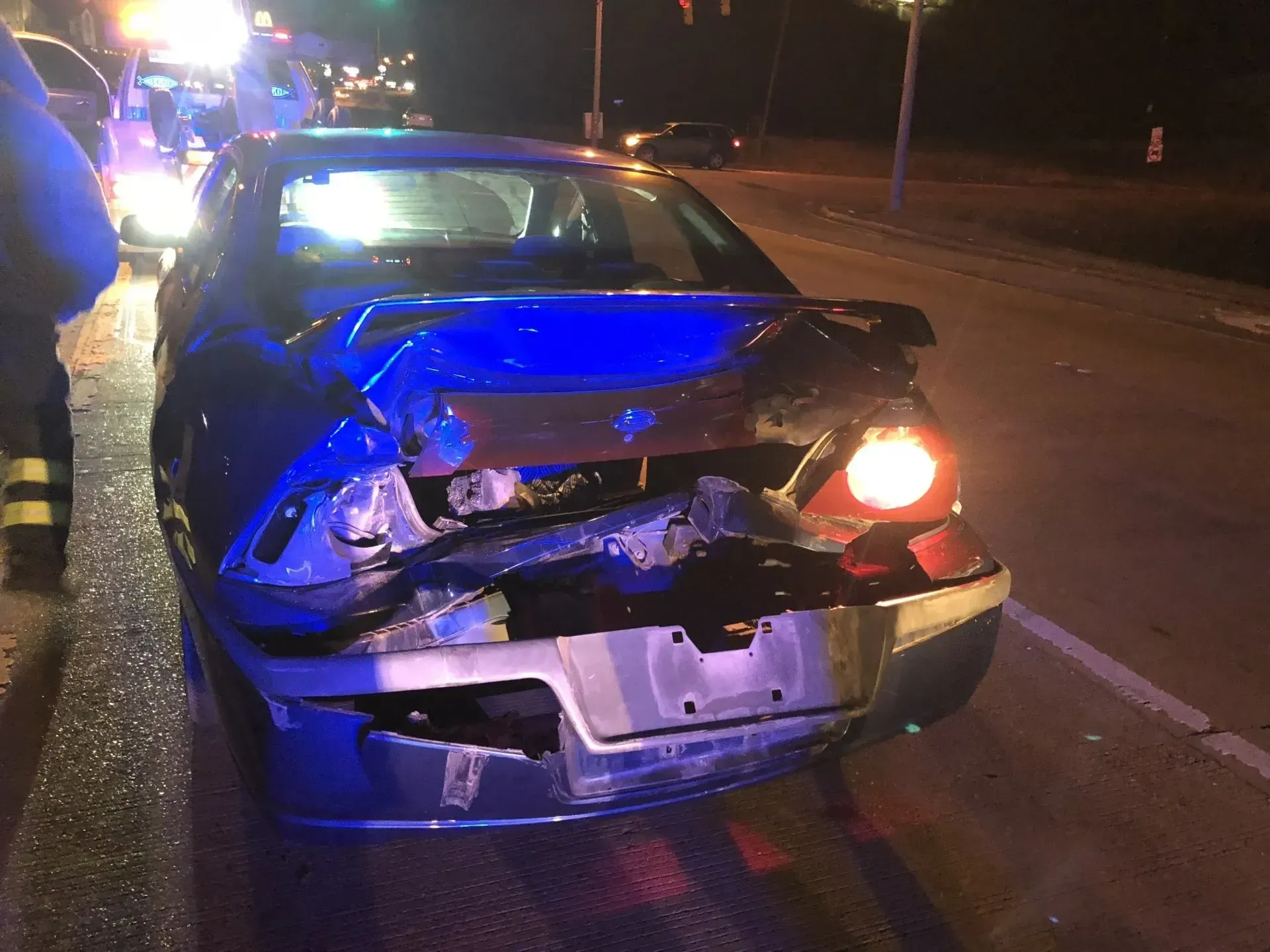 A car that has been damaged in an accident is sitting on the side of the road.