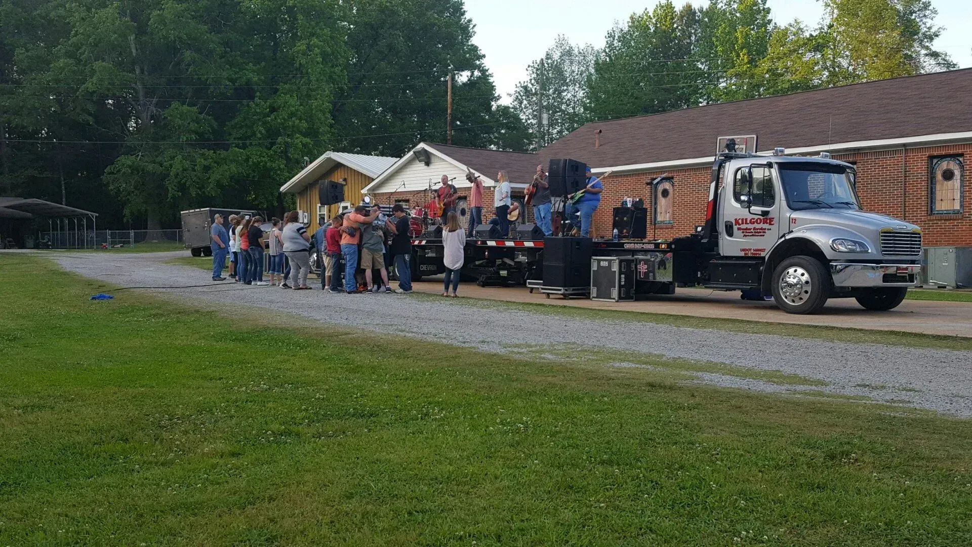 A group of people are standing in front of a tow truck.