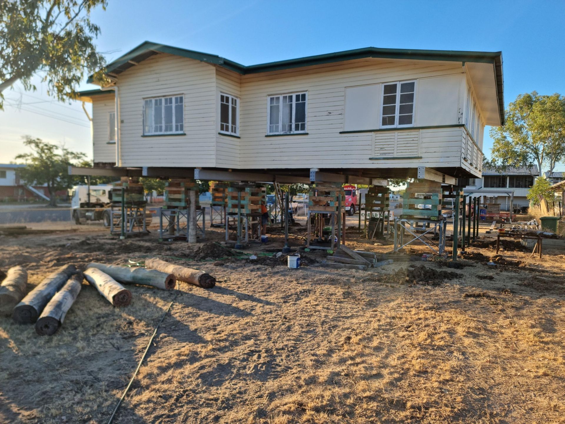 A Large Piece of Wood Is Sitting on Top of A Pile of Dirt — Conan The House Lifter In Townsville, QLD