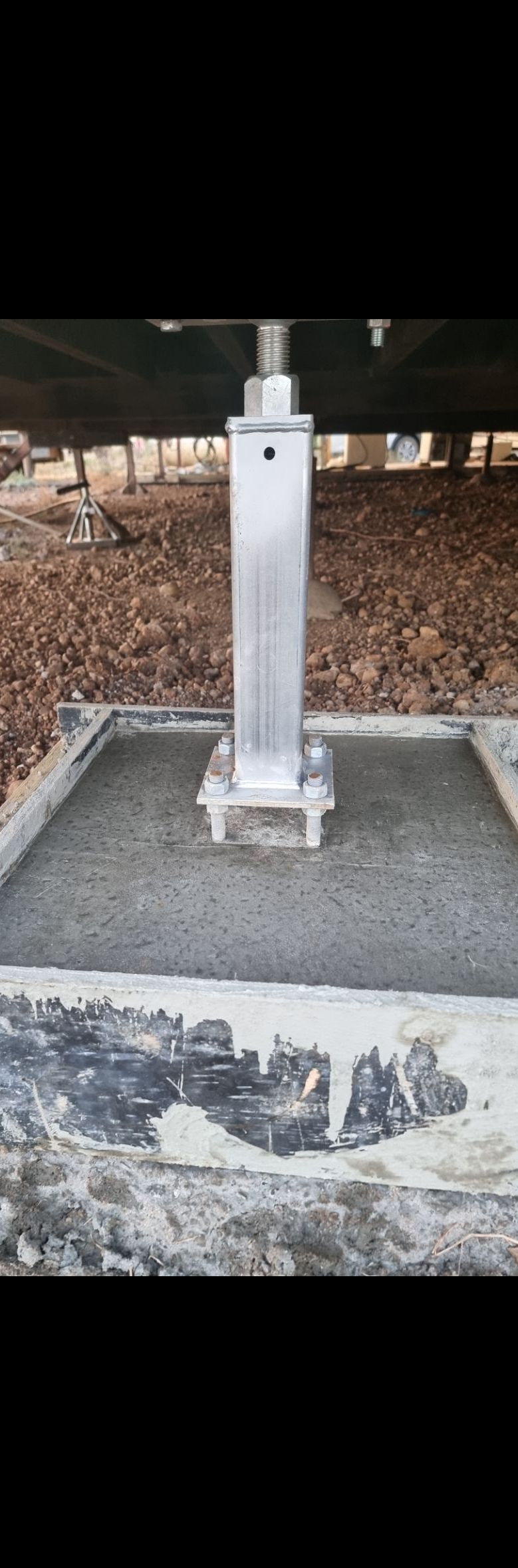 A Metal Pole Is Sitting on Top of A Concrete Base Under a Bridge — Conan The House Lifter In Townsville, QLD