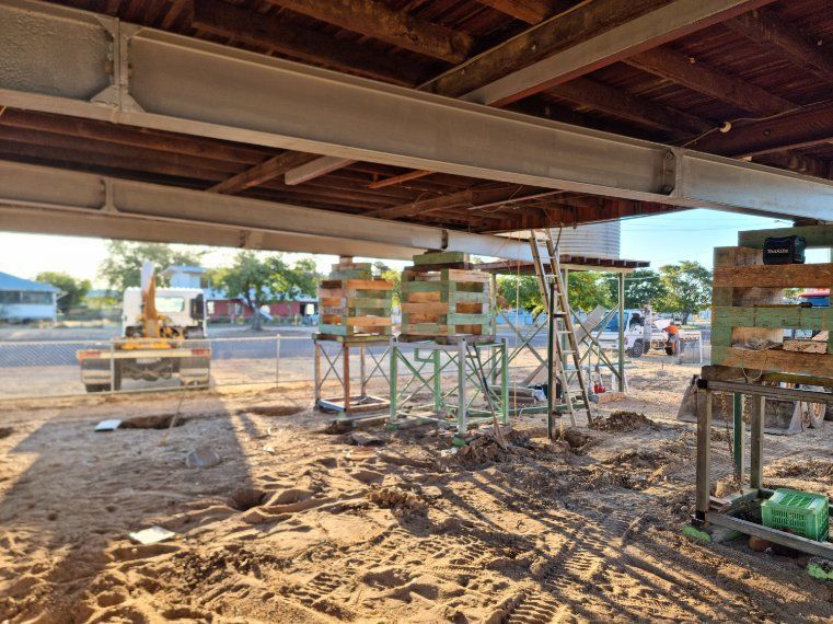 A Construction Site with Scaffolding and A Bulldozer in The Background — Conan The House Lifter In Townsville, QLD