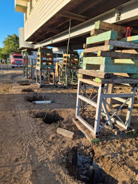 A House Is Being Built on Stilts with A Bulldozer in The Background — Conan The House Lifter In Townsville, QLD