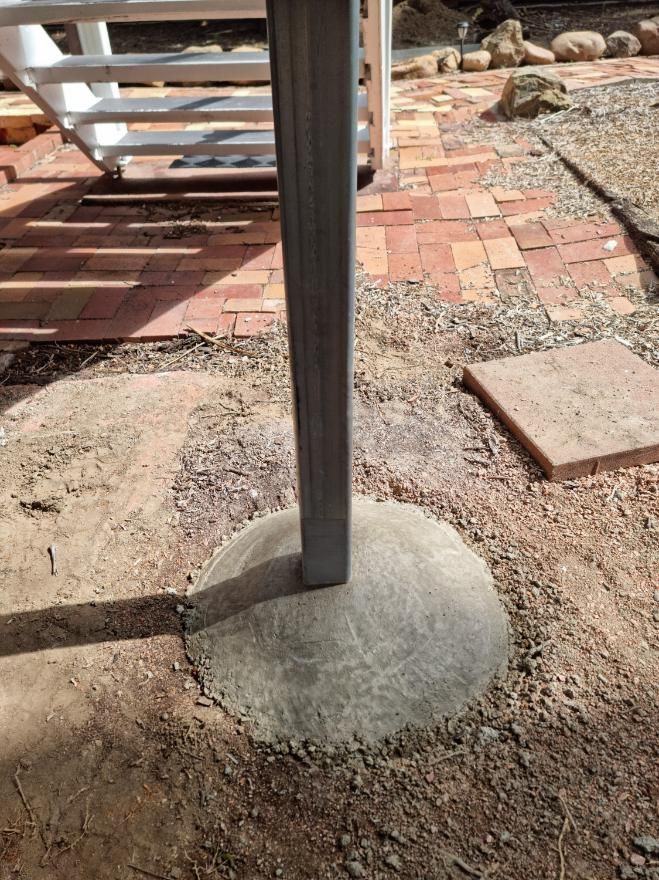 A Metal Pole Is Sitting in The Dirt Next to A Staircase — Conan The House Lifter In Townsville, QLD