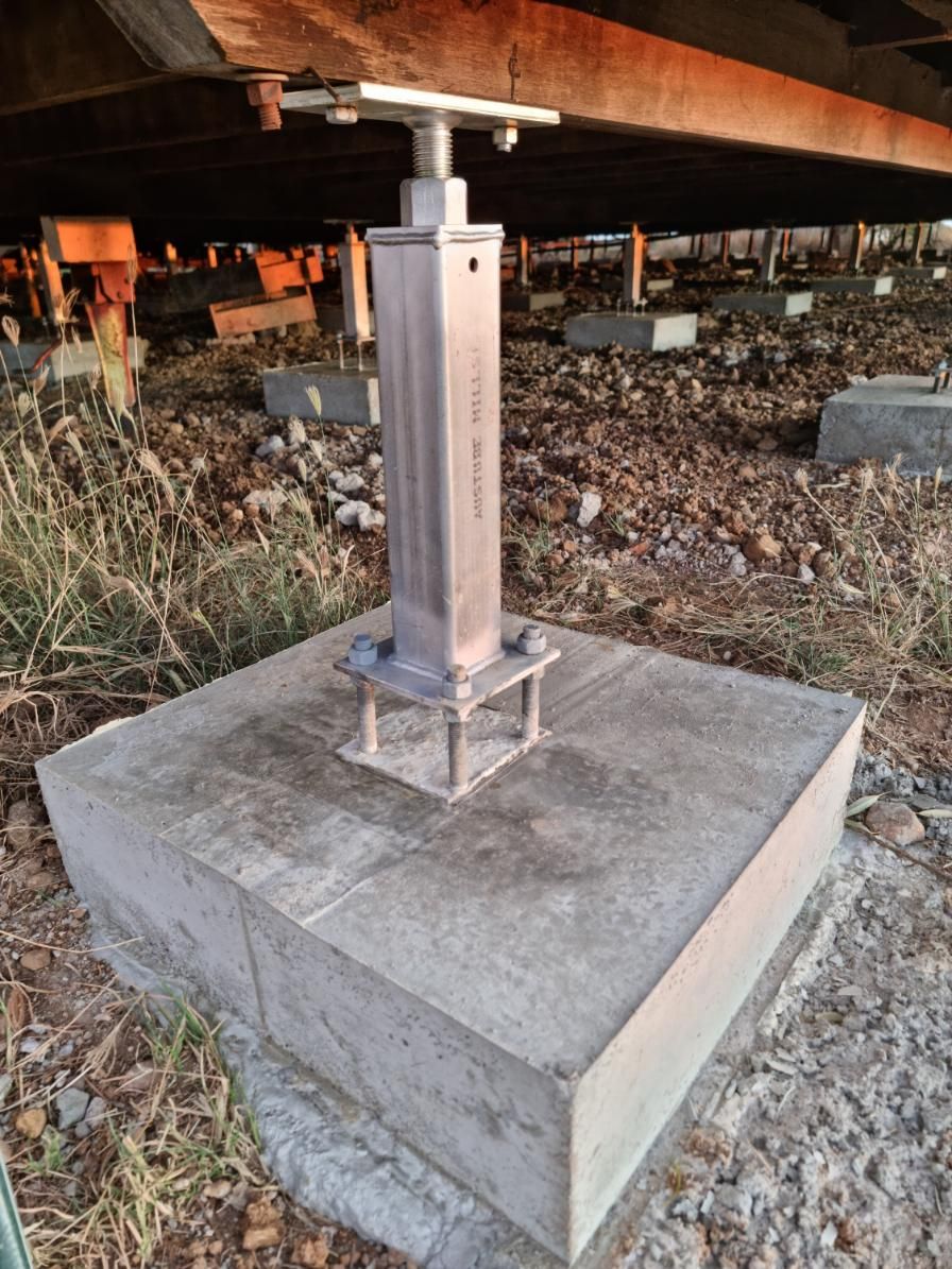 A Metal Pole Is Sitting on Top of A Concrete Base — Conan The House Lifter In Townsville, QLD