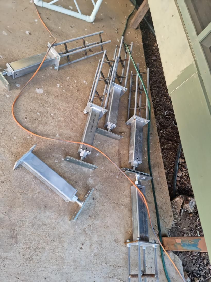 A Bunch of Metal Pieces Are Laying on The Ground Next to A Hose — Conan The House Lifter In Townsville, QLD