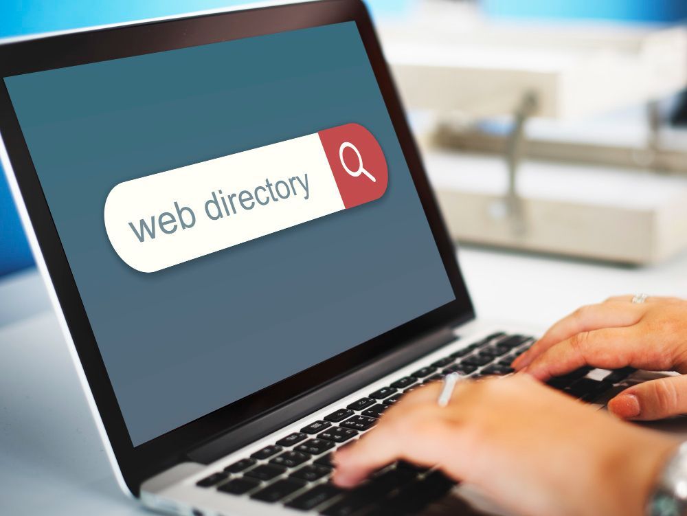 Hands typing on laptop with web directory search box on screen