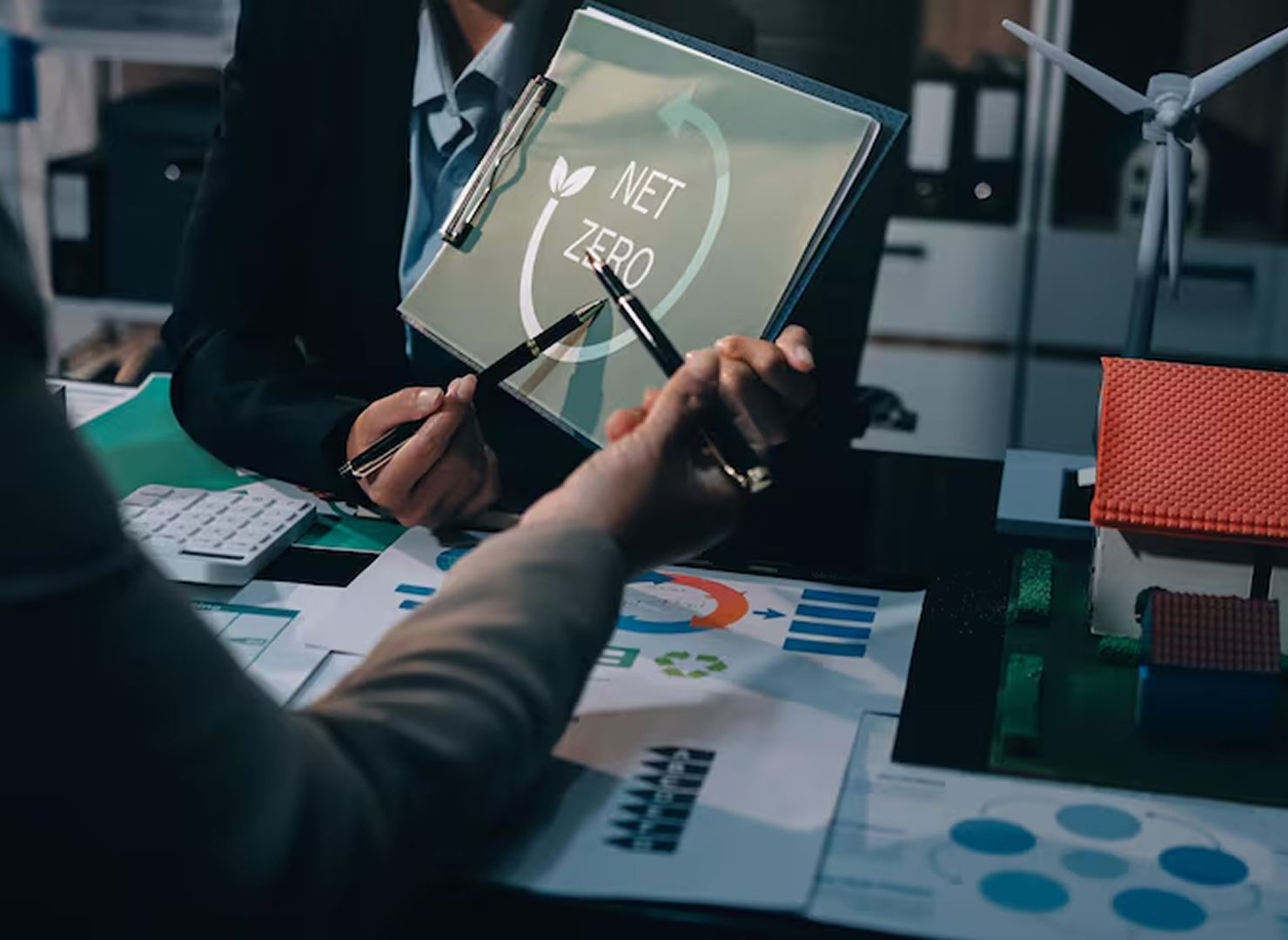 Laptop displaying company growth dashboard on a desk with charts, tablet, papers, and coffee cup