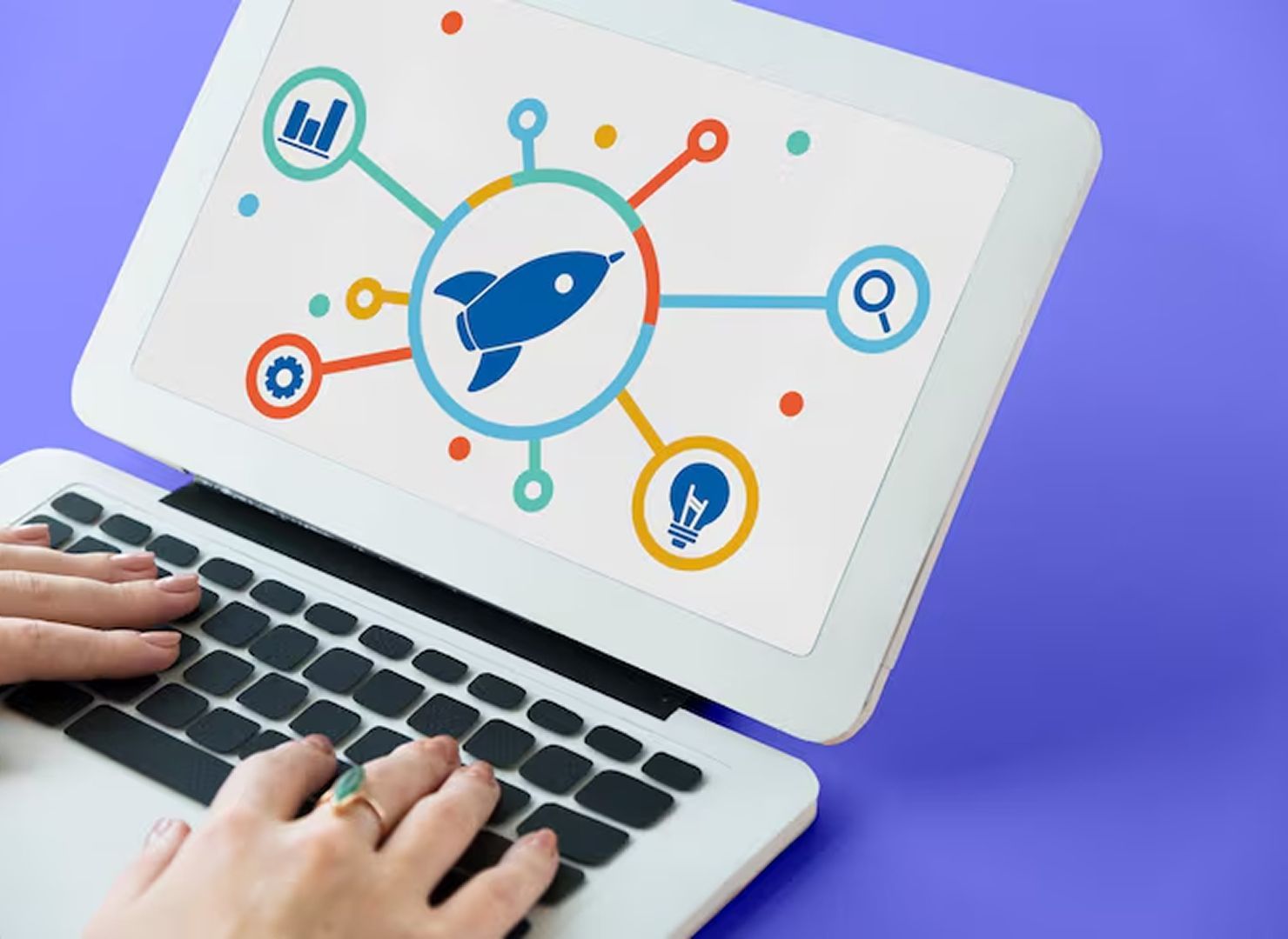 Hands typing on laptop with a rocket startup icon and connected analytics symbols on screen