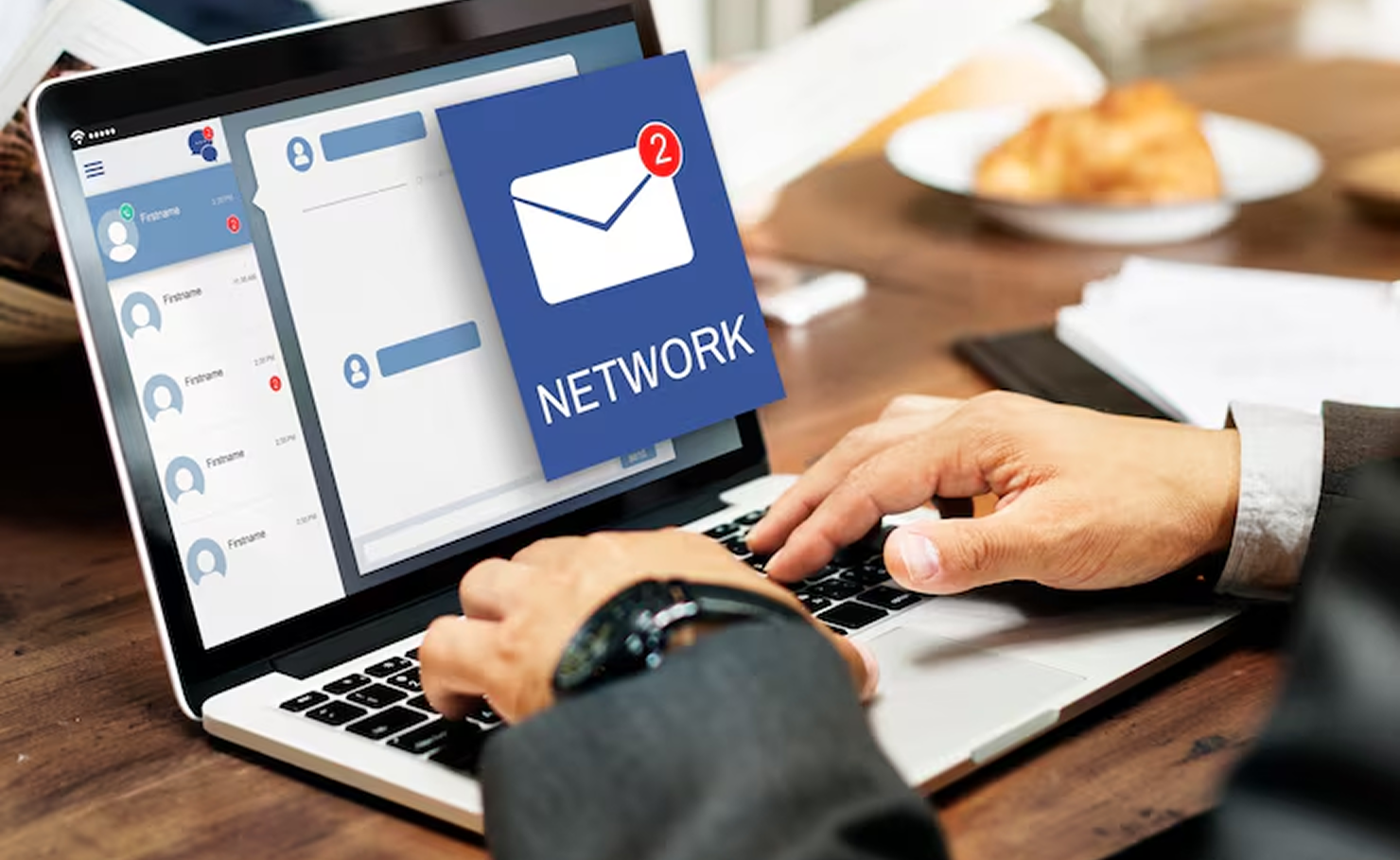 Person typing on laptop with a social media app dashboard and a blue network notification icon on screen
