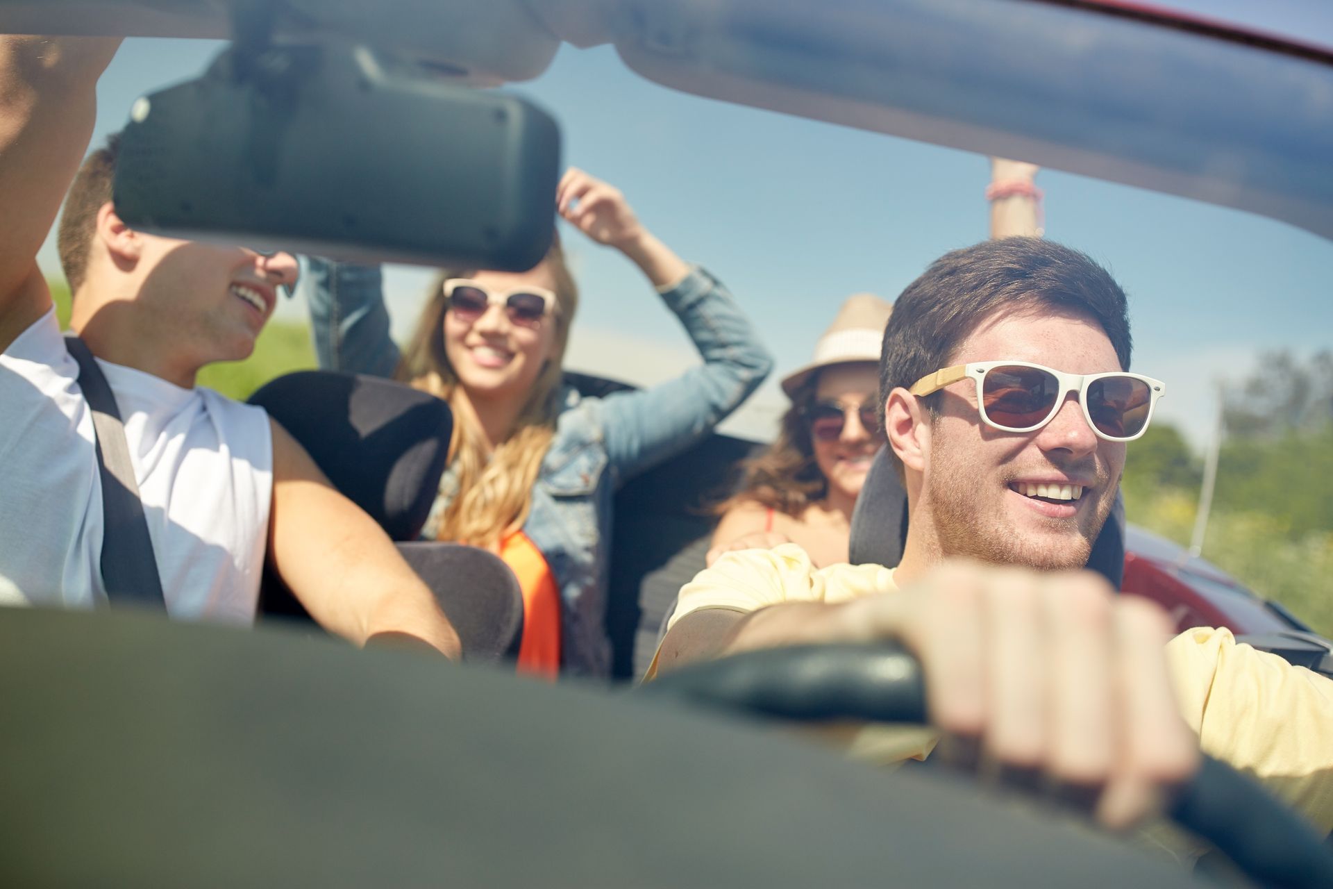 Group of friends enjoying a summer drive together representing increased travel and road activity