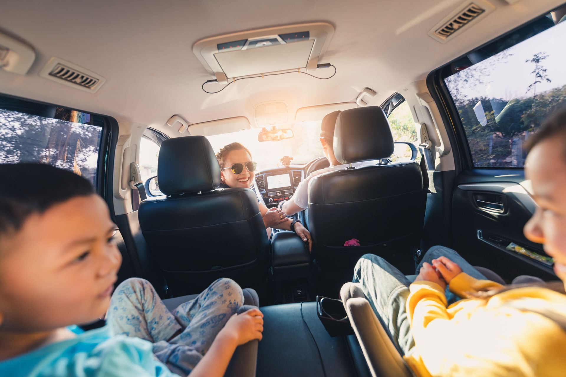 Family road trip in Arizona with kids in backseat and parents driving on sunny highway
