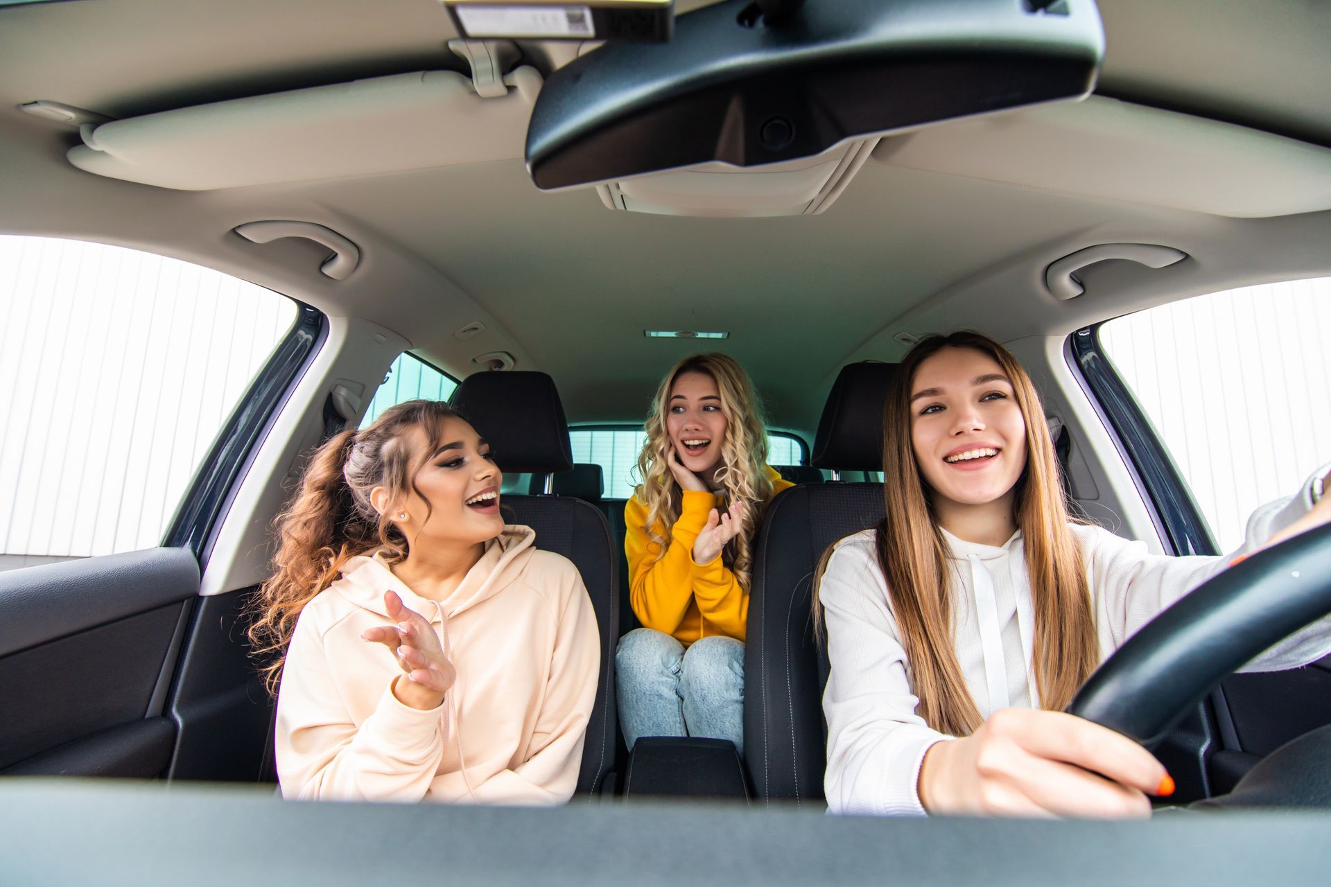 Teen driver with friends in the car showing a common summer driving situation with passengers