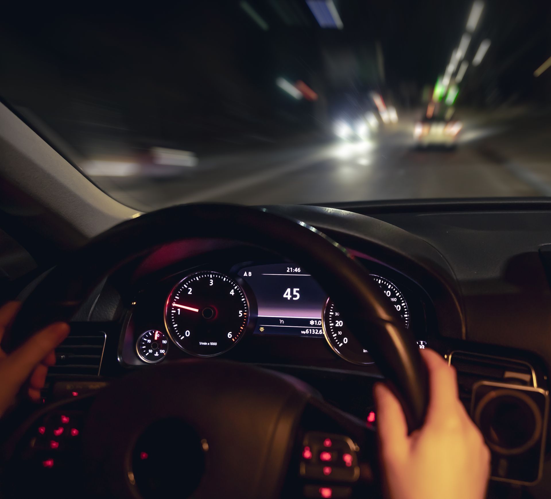 Driver’s view of nighttime highway driving through tunnel, highlighting visibility and road safety concerns
