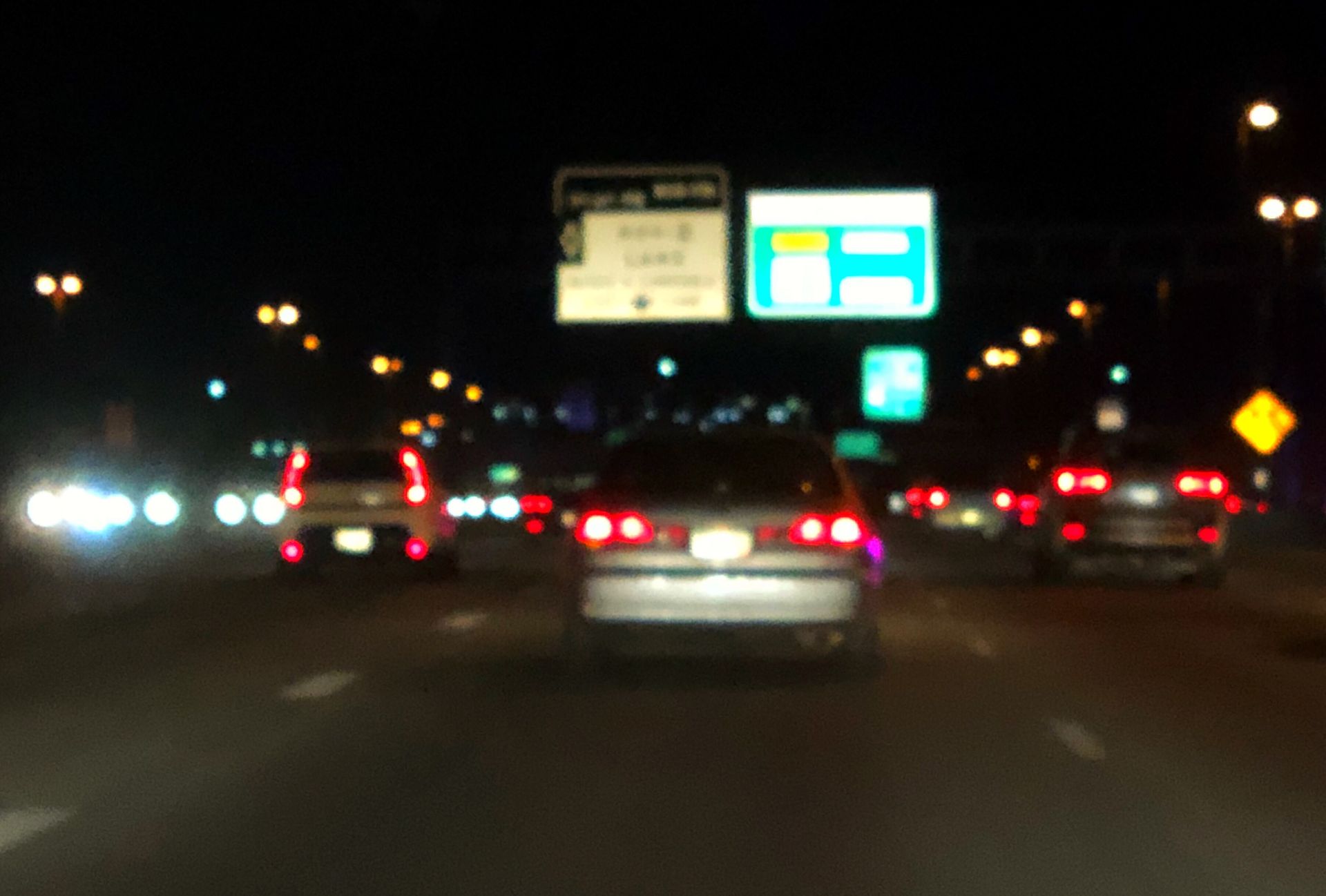Blurred nighttime highway traffic and lights representing fatigue, reduced visibility, and distracted driving risks